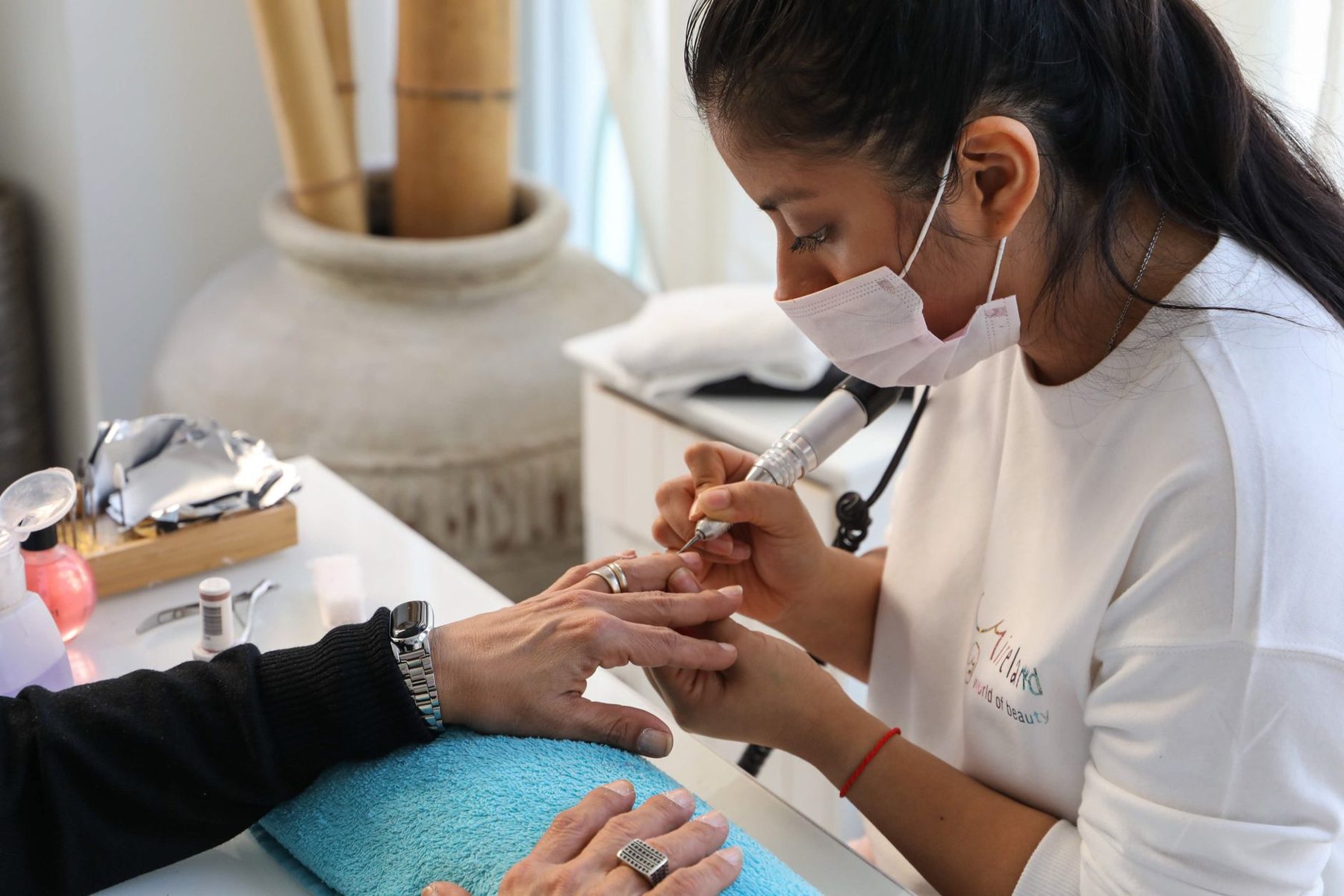 Profesional realizando manicure a una clienta