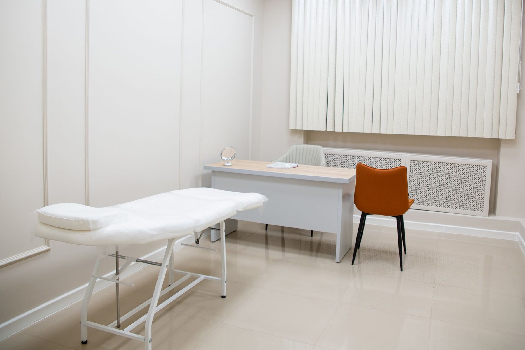 Sala clínica luminosa con camilla, preparada para la atención